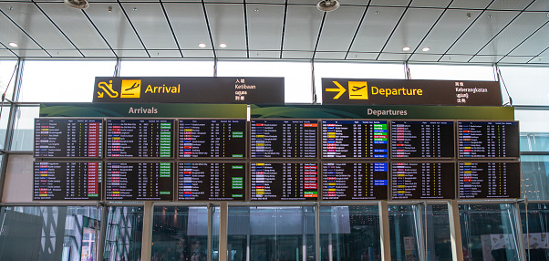 Flights arrival and departure screens display at Singapore Airport lobby.
