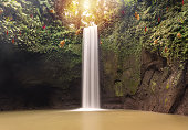 Panoramic scene waterfall in rainforest. Tropical landscape. Adventure and travel concept. Nature background. Slow shutter speed, Tibumana waterfall Bali, Indonesia