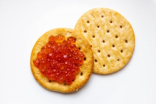Top view of crackers served with red salmon fish caviar