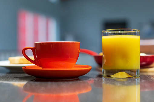 Horizontal color close-up image of delicious breakfast arranged on table. Private swimming pool and sea in the background.