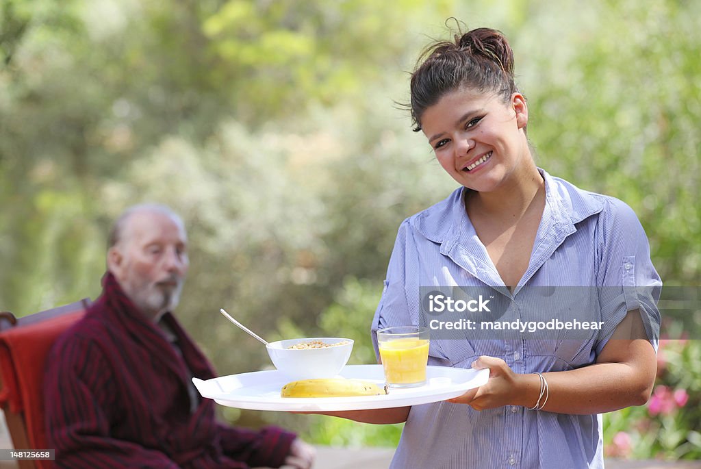 nurse or carer with senior nurse or carer bringing healhty balanced diet breakfast to senior patient Nursing Home Stock Photo