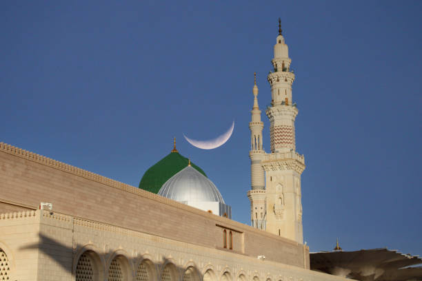 eine moschee mit einer mondsichel am himmel. masjid nabi von medina. grüne kuppel. ramadan kareem. eid mubarak - minarett stock-fotos und bilder