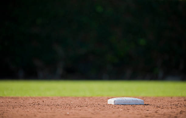 Low angle photo of an empty baseball base Second base and a dark outfield outfield stock pictures, royalty-free photos & images