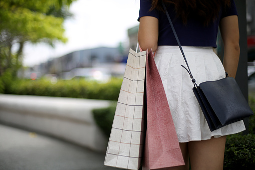 An Asian young woman is enjoying shopping.