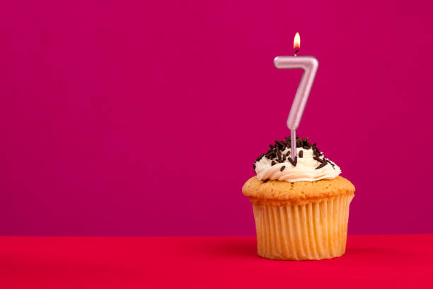 istock Candle number 7 - Cake birthday in rhodamine red background 1481264027