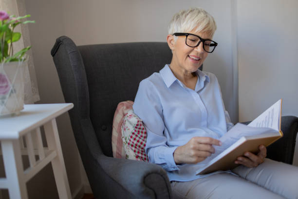 istock Happy woman reading book at home 1481267297