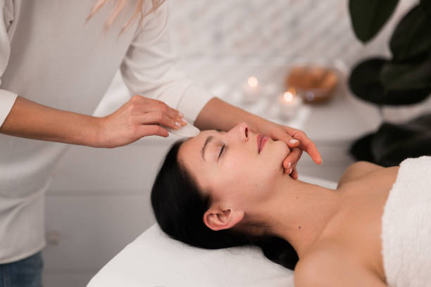 istock Crop masseuse massaging clients face with gua sha 1481267682