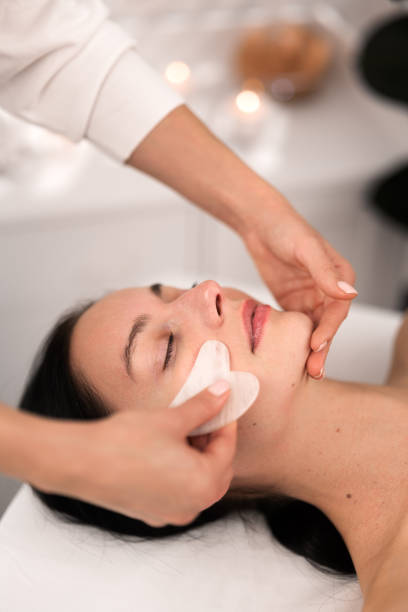 istock Crop beautician doing face massage with gua sha to female customer 1481267686