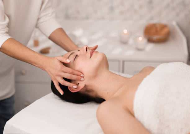 recorte irreconocible terapeuta masajeando la cara de una paciente femenina - head massage massaging facial massage beautician fotografías e imágenes de stock