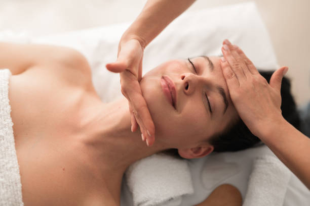 istock Relaxed young woman smiling while lying on table during face massage 1481267767