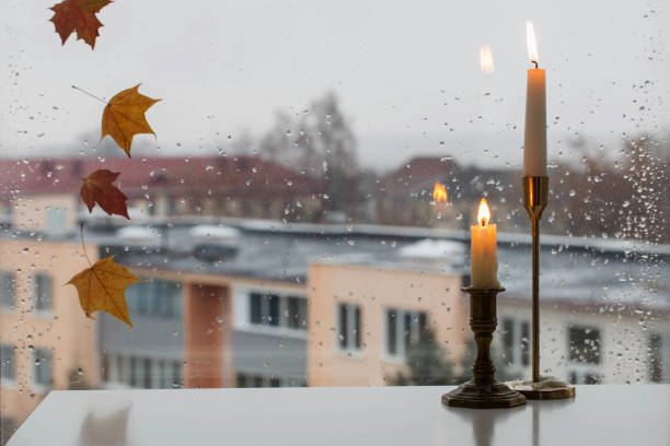 burning candles on background rainy window pane