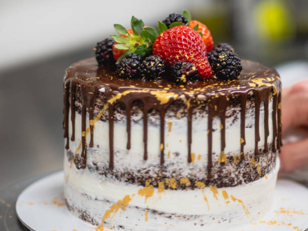 istock pastry chef preparing a chocolate frosted dripped icing cup cake 1481268345