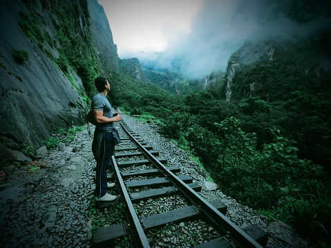 man admiring sightseeing while hiking and exploring the thrills from new heights. A look Into structures and mountains
