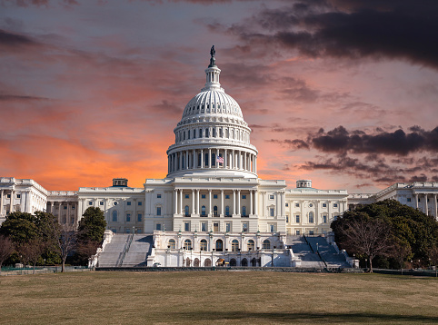 United States Capitol building in Washington DC with sunset sky.