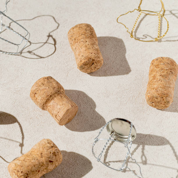 istock Creative composition made of champagne corks on beige sunlit background with shadow. Bottle caps from sparkling wine and metal wire muselet. Summer party drink concept 1481276690