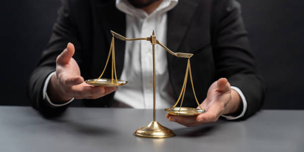 istock Lawyer or judge in formal black suit hold unbalanced scale . equility 1481285900