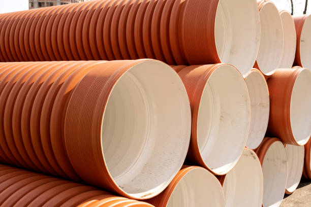 istock Orange plastic pipes used on a construction site. Orange PVC sewer pipe for outdoor use. Stacked in a row premium plastic pipes for wastewater 1481293116