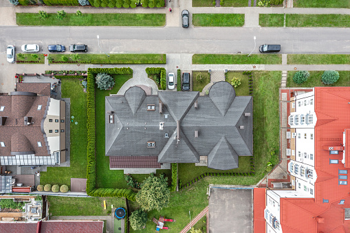 In building construction, a new roof is being installed on a house roof covering asphalt shingles an aerial view