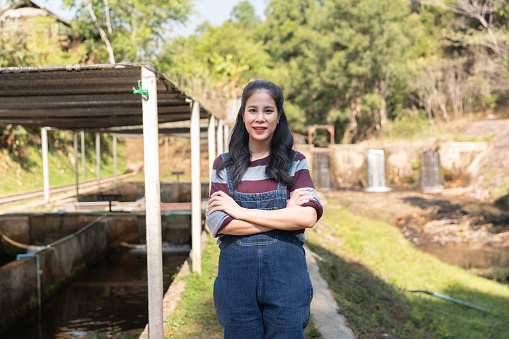 Portrait Asian young woman with her fish farm