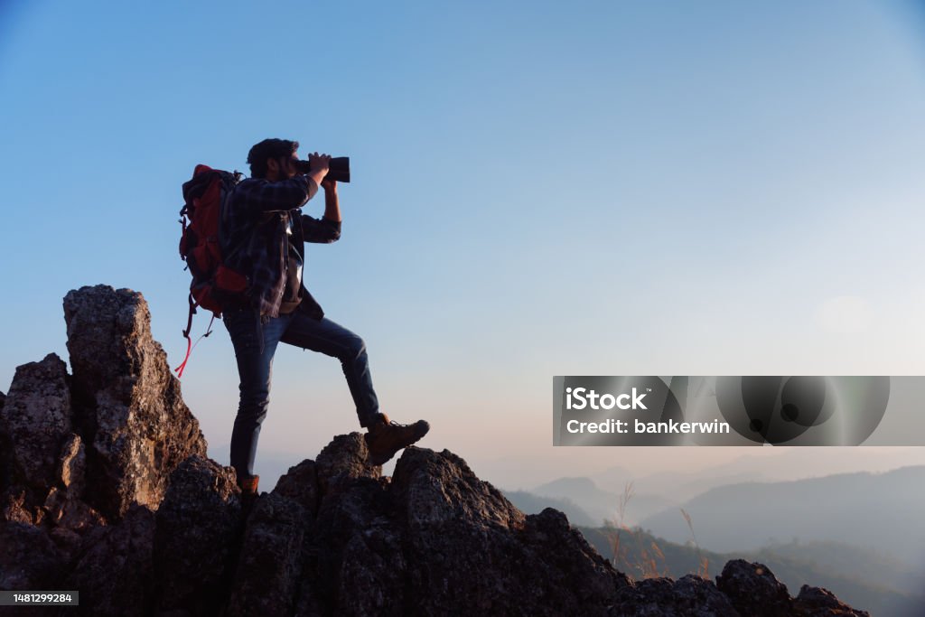 Backpacker Front Facing Asian Backpacker On Mountain Peak And Using Binoculars Looking Forward ...