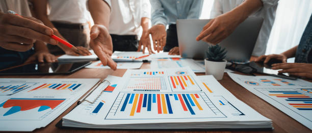 istock Focus financial report papers with blurred analyst team working. Scrutinize 1481305677