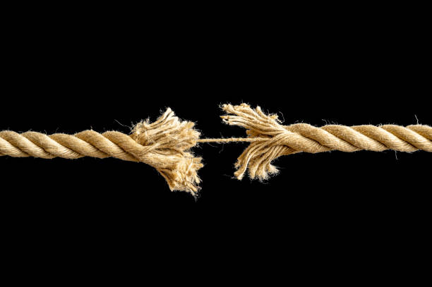 Rope just before the crack against black background Rope in front of a black background that is only held together by a thread rope tearing stock pictures, royalty-free photos & images