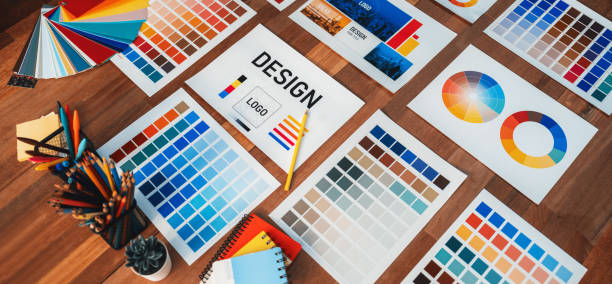 Various color palette idea papers arranged on workspace for designer. Scrutinize