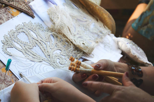 Lace Making: The Art of Precision Close-up photo of a woman and a girl making lace using bobbins lacemaking photos stock pictures, royalty-free photos & images