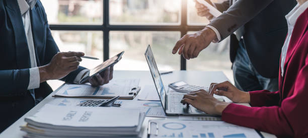 istock Business People Meeting using laptop computer,calculator,notebook,stock market chart paper for analysis Plans to improve quality next month. Conference Discussion Corporate Concept. 1481308407