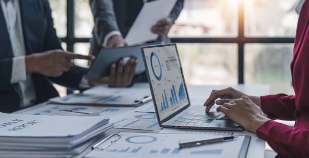 istock Business People Meeting using laptop computer,calculator,notebook,stock market chart paper for analysis Plans to improve quality next month. Conference Discussion Corporate Concept. 1481308468