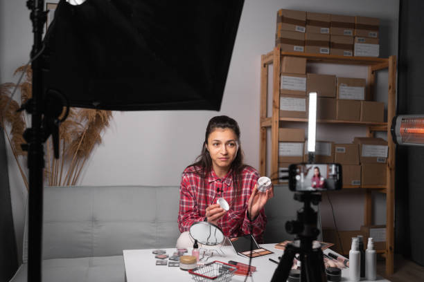 Beauty influencer streaming from home using camera, promoting cosmetics, copy space. Women's business