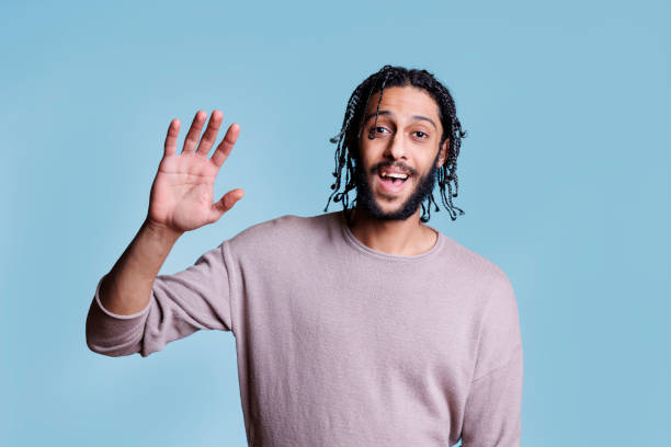 istock Man waving hi with hand with cheerful facial expression 1481312775