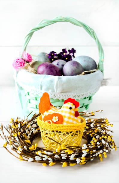 istock Easter eggs in a wicker basket on a white background. Decorative chicken with Easter eggs. Easter composition with space for text 1481313462