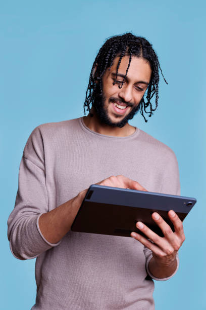 istock Smiling arab man typing online message on digital tablet 1481313568