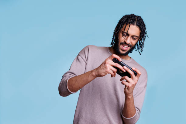 istock Smiling young arab man playing video game on smartphone 1481313596