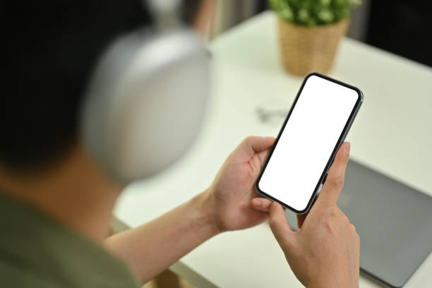 istock Close up view of man wearing wireless headphone using mobile phone. Blank screen for advertising text message. 1481313834