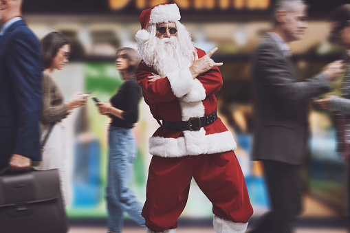 Cool Santa Claus in the city street making the rocker gesture, rock Christmas concept