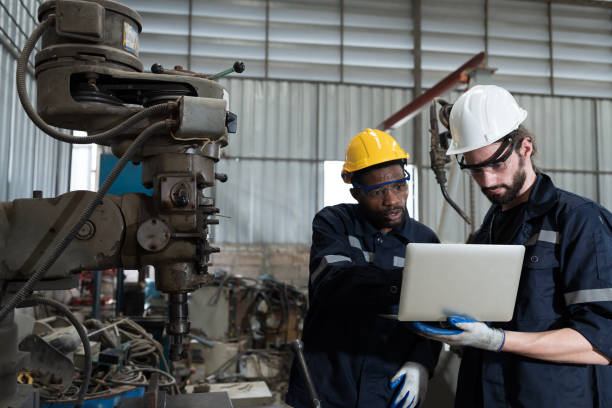 istock Two male technician using laptop computer for checking lathe machine in factory, maintenance CNC machine in workshop 1481316735