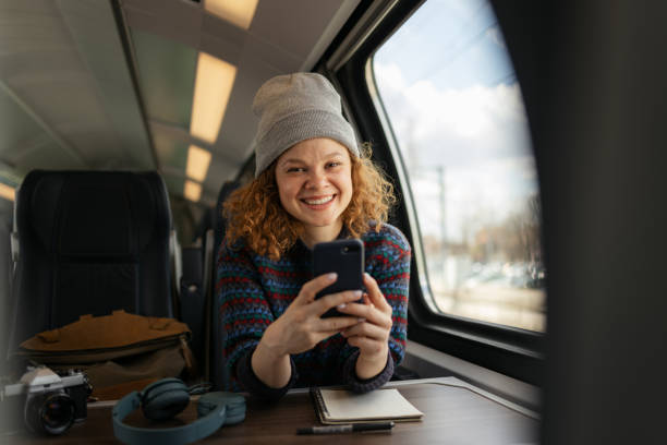 istock Happy redhead woman using mobile phone during her trip by train. 1481319125