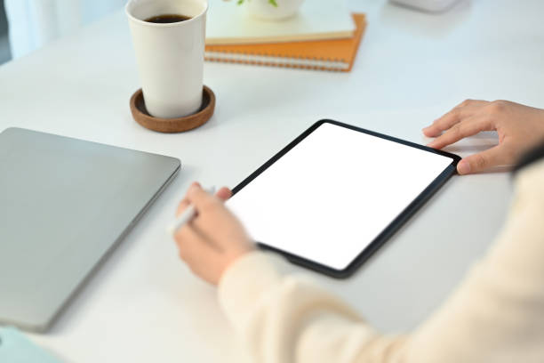 istock Close up view of young female freelancer working online, browsing internet via digital tablet at working desk. 1481319135
