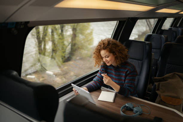 istock Young redhead woman using touchpad in a train. 1481319181