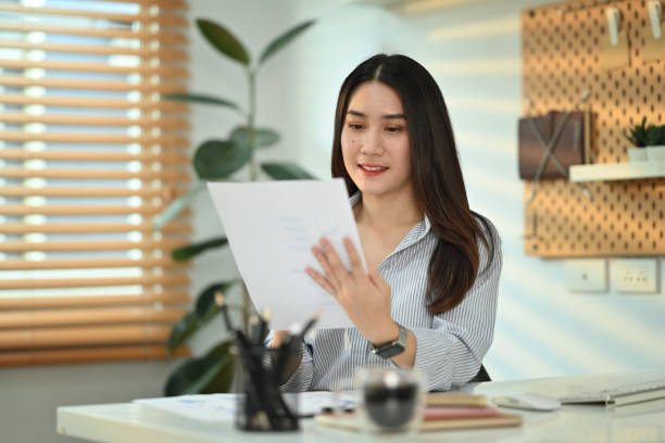 istock Charming asian female accountant working bookkeeping documents, checking financial data at office. 1481319190