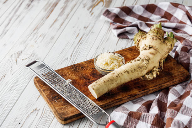 aromatic horseradish root on a white rustic wooden background