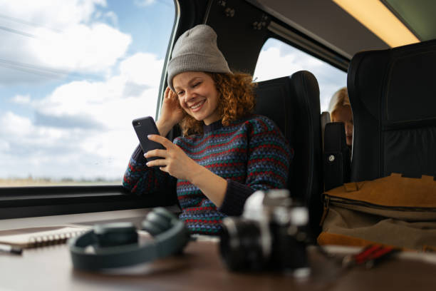 istock Happy female tourist text messaging on mobile phone while traveling by train. 1481320653