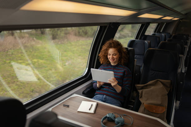 istock Happy female tourist using digital tablet in a train. 1481320714