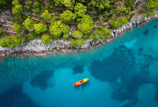 Aerial view on woman kayaking in turquoise sea of Hvar Island, Croatia.