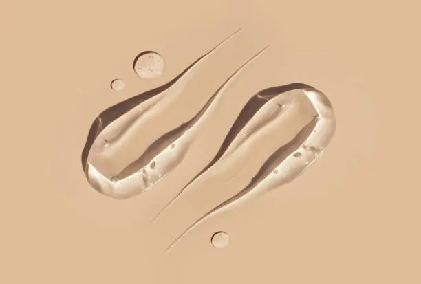 Photo of cosmetic smears gel texture on pastel beige background