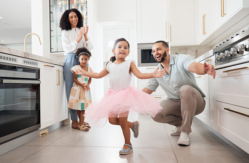 Dance, princess and family with children in home kitchen for love, care and fun bonding together, clapping or celebration. Support, dancing and Mexico girl or kid with parents or mother and father