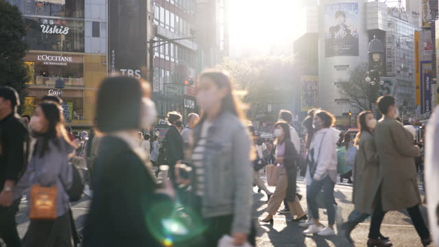 Pedestrians cross at Shibuya Crossing in Tokyo , Japan