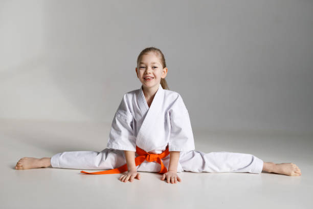 istock A little girl in a white kimono sits on a twine, karate training. 1481328149